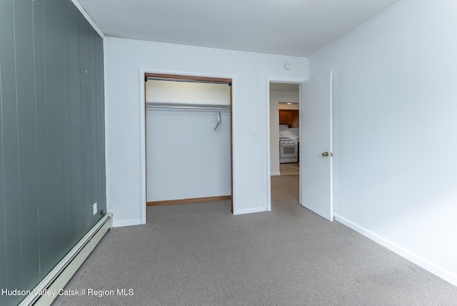 unfurnished bedroom featuring a closet, a baseboard heating unit, baseboards, and carpet floors