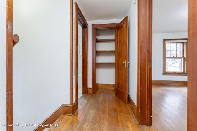 hallway with baseboards and wood finished floors