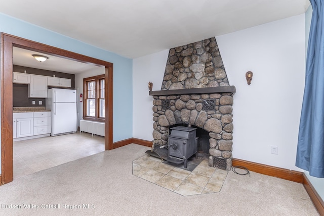 living room with baseboards, radiator heating unit, and a wood stove