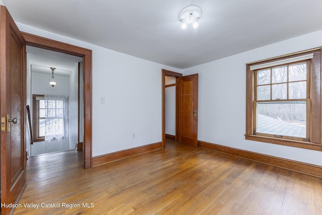 interior space featuring light wood-type flooring and baseboards