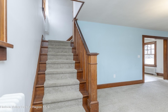 stairs with carpet flooring, radiator heating unit, and baseboards