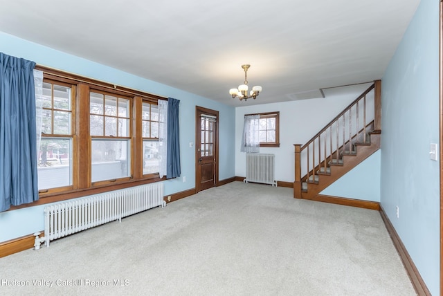 carpeted foyer entrance with baseboards, stairs, radiator heating unit, and an inviting chandelier