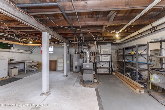 below grade area featuring water heater, washer / clothes dryer, electric water heater, and a wall mounted AC