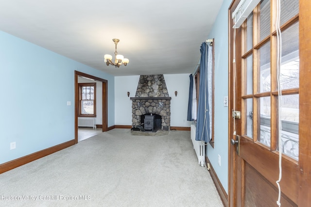 living area featuring a chandelier, carpet flooring, radiator, and baseboards