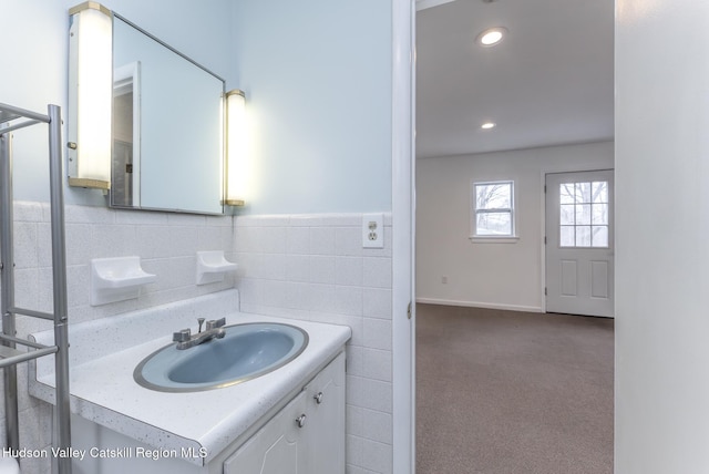 bathroom featuring recessed lighting, a wainscoted wall, tile walls, and vanity