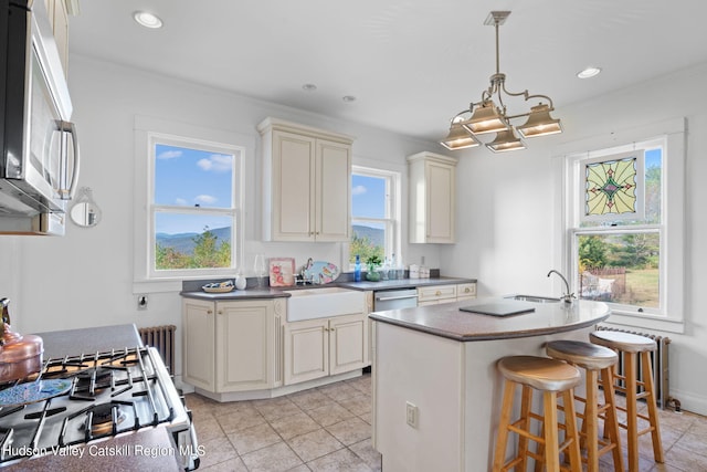 kitchen featuring a wealth of natural light, sink, a kitchen island with sink, and appliances with stainless steel finishes