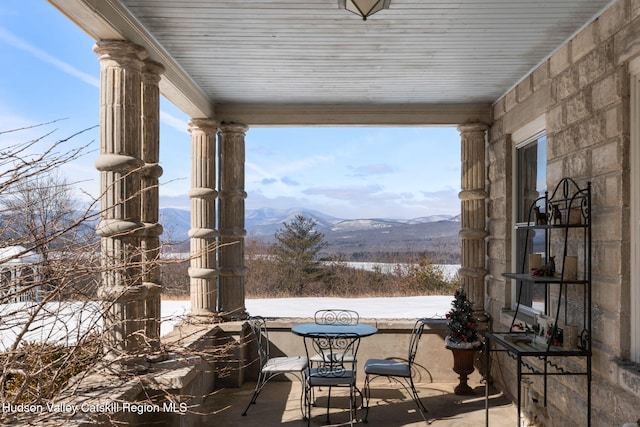 snow covered patio with a mountain view