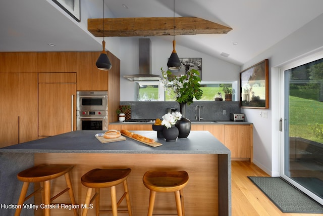 64 Dug Rd, Accord, NY 12404 - kitchen featuring island range hood, double oven, light wood-type flooring, backsplash, and a kitchen breakfast bar