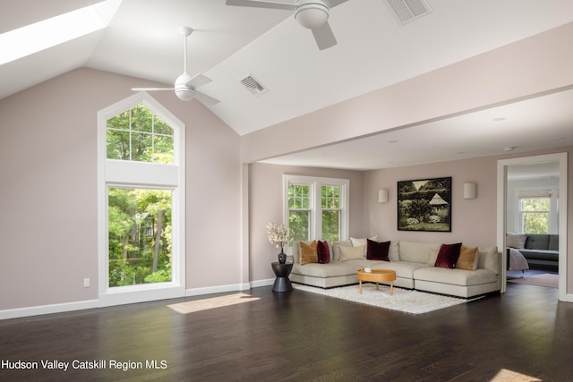 living room with plenty of natural light, ceiling fan, and dark wood-type flooring