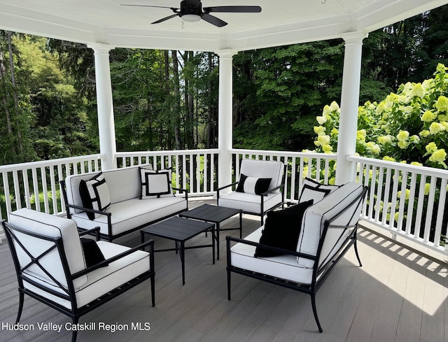 wooden deck with an outdoor living space and ceiling fan