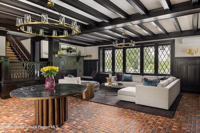 living room featuring a wall mounted air conditioner, beam ceiling, and a chandelier