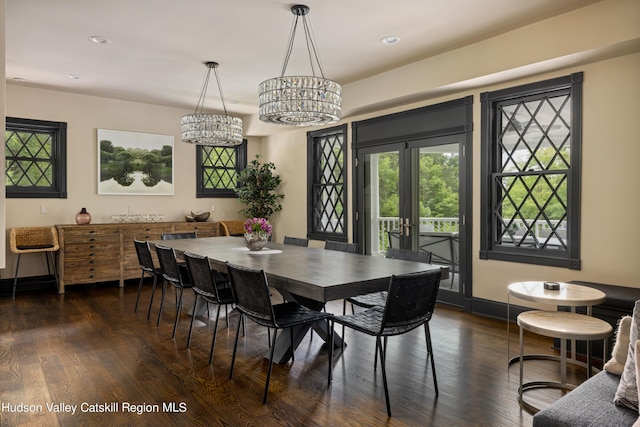 dining area with dark hardwood / wood-style flooring, french doors, and an inviting chandelier