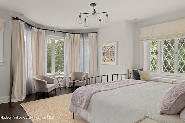 bedroom featuring dark wood-type flooring and a chandelier