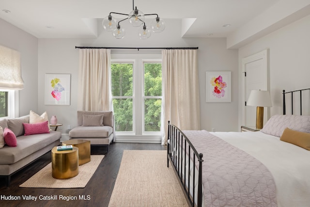 bedroom with dark hardwood / wood-style flooring and a notable chandelier