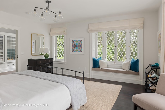 bedroom featuring dark hardwood / wood-style flooring and a chandelier