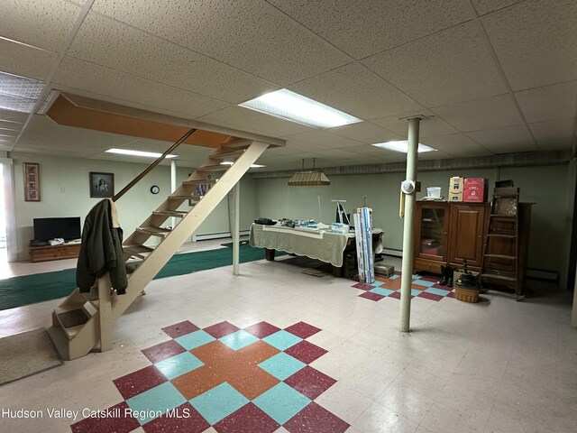 50 County Rte 26, Coxsackie, NY 12192 - finished basement with tile patterned floors, a paneled ceiling, stairs, and a baseboard heating unit