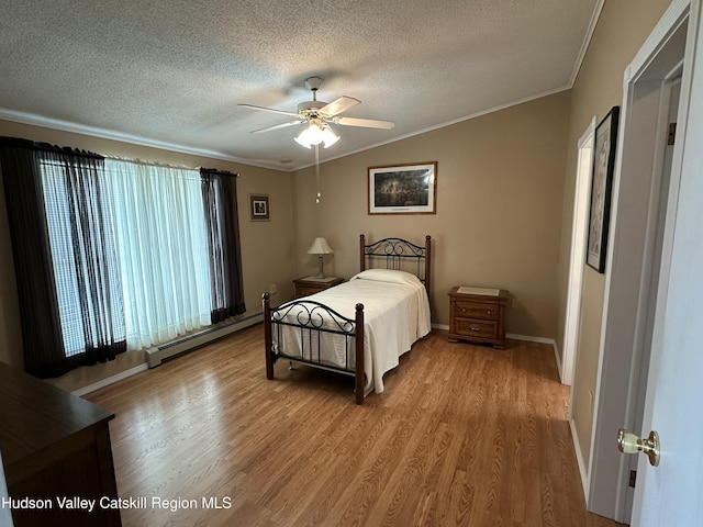 50 County Rte 26, Coxsackie, NY 12192 - bedroom with a baseboard heating unit, wood finished floors, a textured ceiling, crown molding, and baseboards