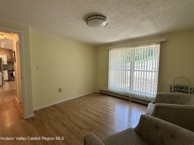 50 County Rte 26, Coxsackie, NY 12192 - living room featuring a baseboard heating unit, wood finished floors, a textured ceiling, and baseboards