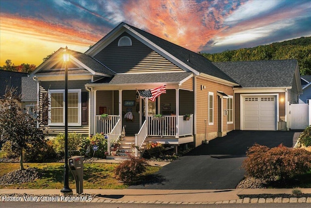 view of front facade with covered porch and a garage