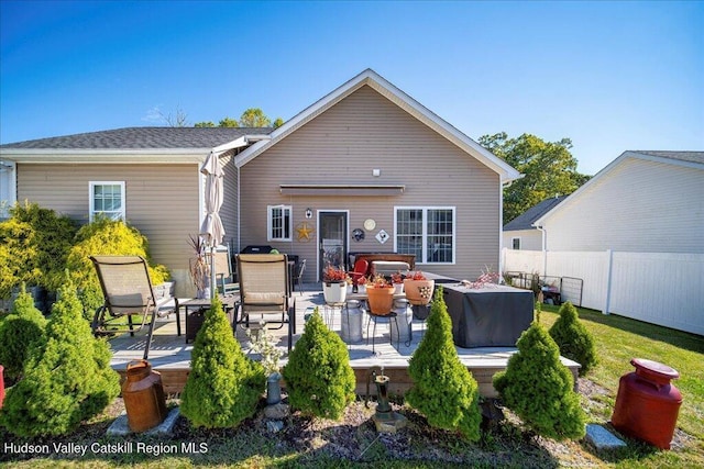 back of property with a hot tub and a patio