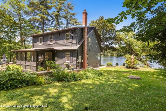 162 Methodist Farm Rd, Averill Park, NY 12018 - rear view of house with a sunroom, a lawn, a chimney, and a water view