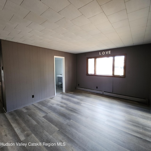 148 Lake Shore Dr, Copake, NY 12516 - empty room with a baseboard heating unit and wood finished floors