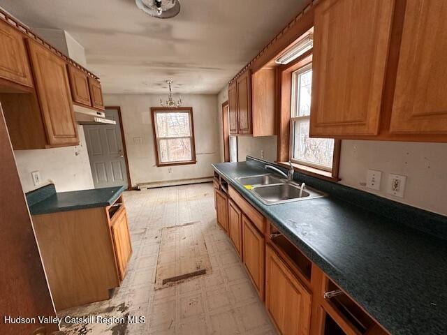 kitchen with pendant lighting, sink, a wealth of natural light, and a baseboard heating unit