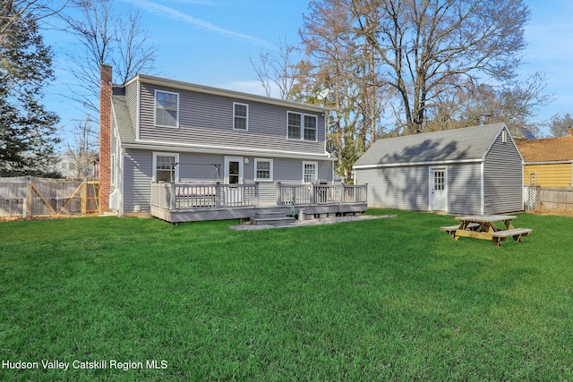 back of property with a yard, a deck, and a fenced backyard