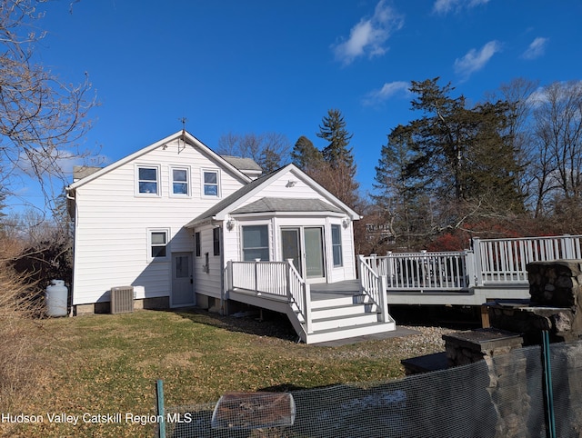 rear view of house featuring a yard and a deck