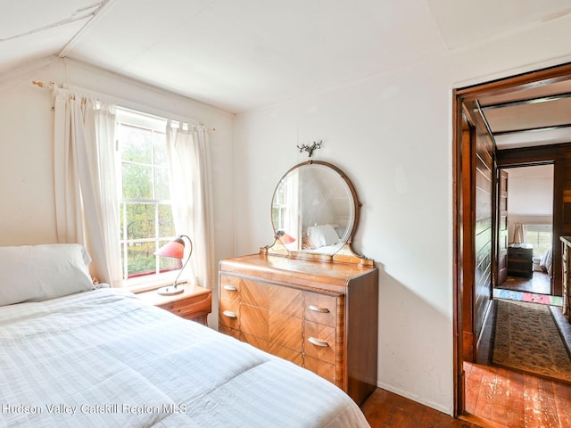 bedroom with dark hardwood / wood-style floors and lofted ceiling