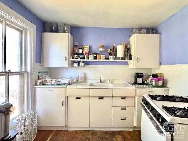 22 Liberty St, Catskill, NY 12414 - kitchen featuring white gas stove, light countertops, dark wood finished floors, and white cabinets