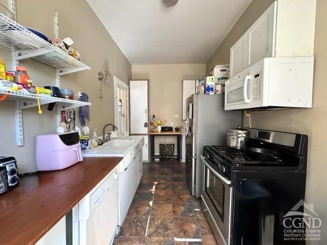 22 Liberty St, Catskill, NY 12414 - kitchen with white appliances, stone finish flooring, a sink, open shelves, and white cabinets