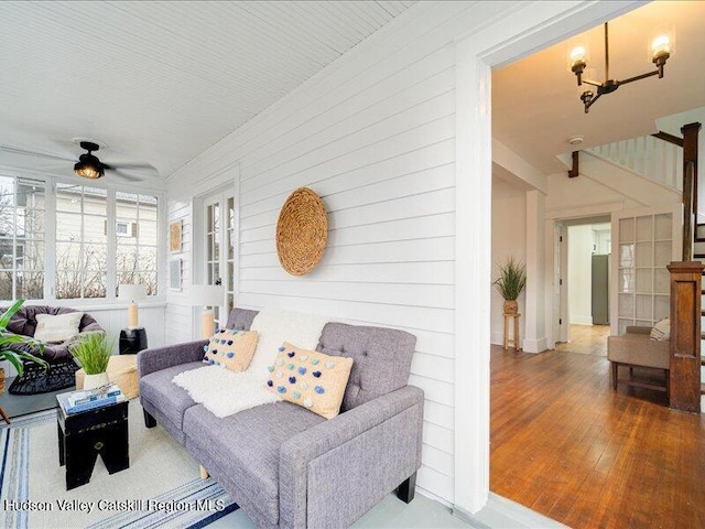 living room featuring hardwood / wood-style floors and ceiling fan with notable chandelier