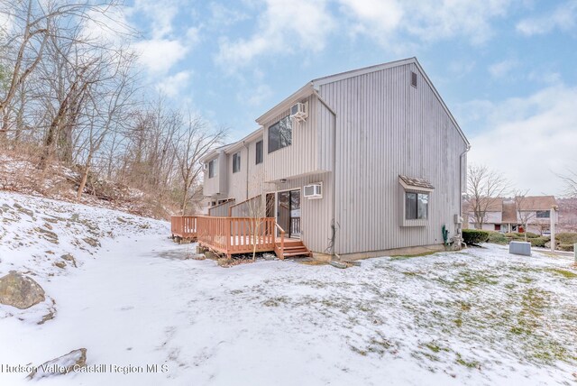 snow covered rear of property featuring a deck