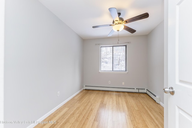 spare room featuring ceiling fan, light wood-type flooring, and baseboard heating