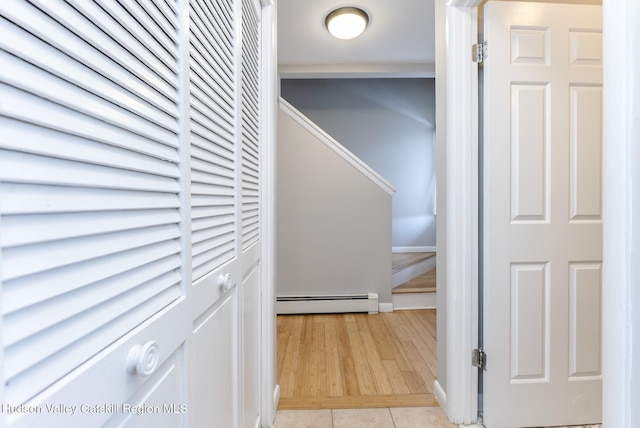 hallway with light tile patterned floors and baseboard heating