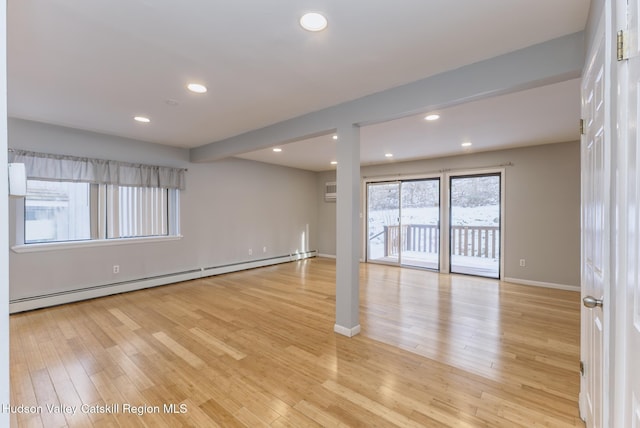 empty room featuring baseboard heating and light wood-type flooring