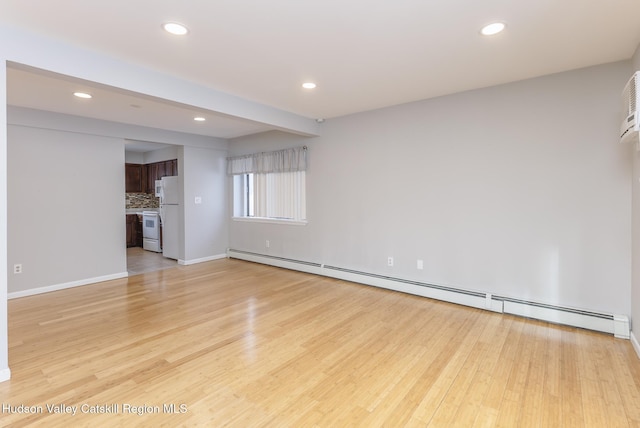 unfurnished living room featuring light hardwood / wood-style flooring and a baseboard radiator