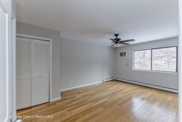 unfurnished bedroom featuring ceiling fan, light hardwood / wood-style floors, a closet, and a baseboard heating unit