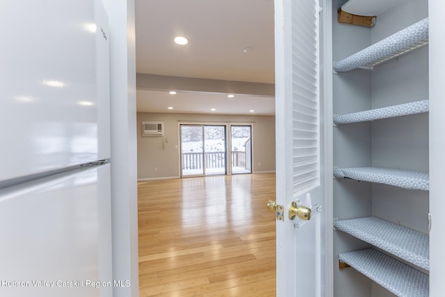 interior space with a wall mounted AC and light wood-type flooring