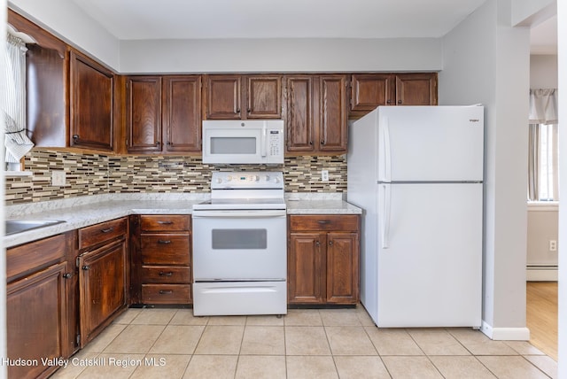 kitchen featuring light tile patterned floors, decorative backsplash, white appliances, and baseboard heating