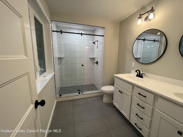 bathroom featuring tile patterned flooring, toilet, an enclosed shower, and vanity