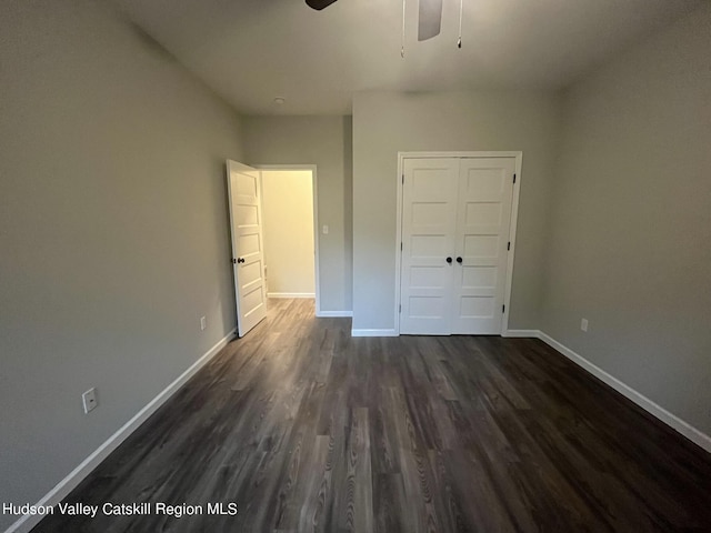 unfurnished bedroom featuring ceiling fan, dark hardwood / wood-style flooring, and a closet