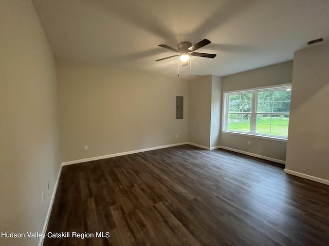 empty room with electric panel, ceiling fan, and dark wood-type flooring