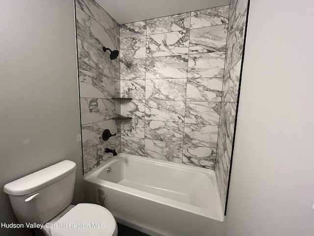 bathroom featuring toilet and tiled shower / bath