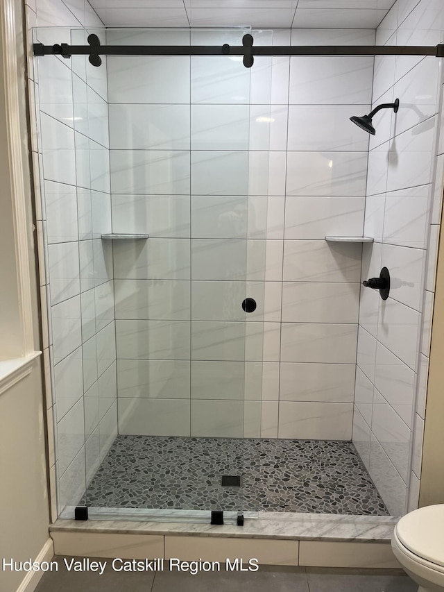 bathroom with toilet and a shower with shower door