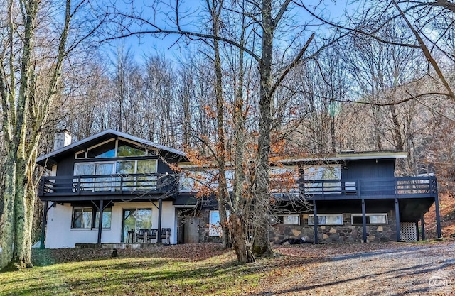 181 Mountain Dr, Hunter, NY 12442 - back of property featuring stone siding, a chimney, a lawn, a deck, and a balcony