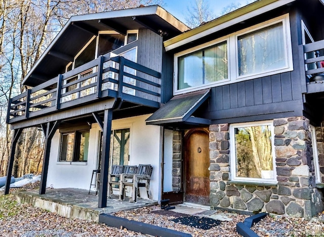 181 Mountain Dr, Hunter, NY 12442 - view of front of property with stone siding, a patio area, a balcony, and stucco siding