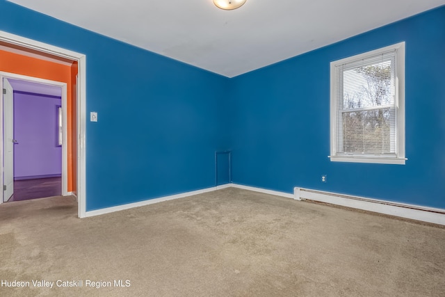 spare room featuring a baseboard radiator, carpet, and baseboards