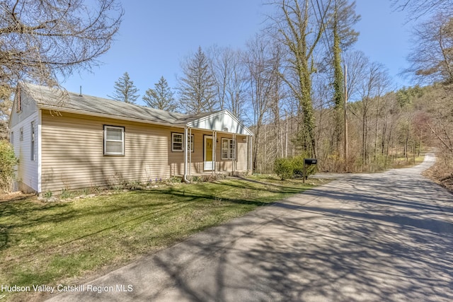 view of property exterior with covered porch and a yard
